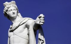 A statue of Greek god Apollo against a blue background