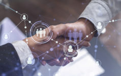 Recruitment concept of hiring of a new talented specialists for international company. Handshake as a concept of agreement to sign an employment contract. Social media hologram icons.