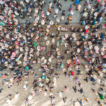 Birds eye view of crowds of people walking through a city