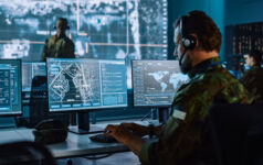 Military Surveillance Officer Working on a City Tracking Operation in a Central Office Hub for Cyber Control and Monitoring for Managing National Security, Technology and Army Communications.