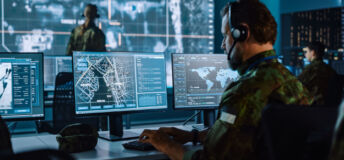 Military Surveillance Officer Working on a City Tracking Operation in a Central Office Hub for Cyber Control and Monitoring for Managing National Security, Technology and Army Communications.