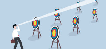 A business man looking past multiple bulleye targets to a final target in the distance