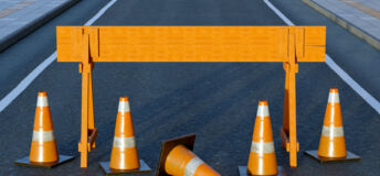 Under construction traffic cones and orange barrier road boundary.