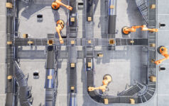 Top down view of a manufacturing facility with conveyor belts and robotic arms