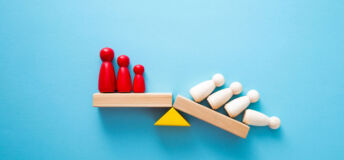 Wooden figures on a shelf, half of whom are falling off