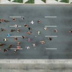 Private equity has entered a hyper-competitive era โ Bain report Aerial view of marathon city runners. One person leading marathon.