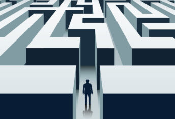 A man stands at the entrance of a maze