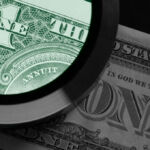 The end of blind faith A photo of a magnifying glass examining a US dollar note