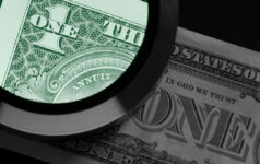 The end of blind faith A photo of a magnifying glass examining a US dollar note