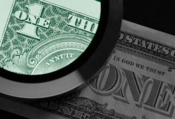 A photo of a magnifying glass examining a US dollar note